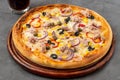 Pizza with tuna, onions and olives on cutting board on stone table Royalty Free Stock Photo