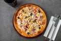 Pizza with tuna, onions and olives on cutting board on stone table Royalty Free Stock Photo