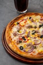 Pizza with tuna, onions and olives on cutting board on stone table Royalty Free Stock Photo