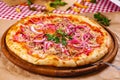 Pizza with tuna and red onion on wooden cutting board Royalty Free Stock Photo