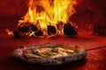 Pizza in wood fired oven with open fire
