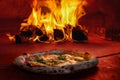 Pizza in wood fired oven with open fire Royalty Free Stock Photo