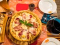 Pizza on a wooden plate. Delicious pizza served on wooden table Royalty Free Stock Photo