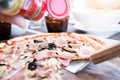 Pizza on wooden plate on table Royalty Free Stock Photo