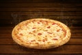 Pizza on wooden table. Flying hot pizza margarita closeup with mozzarella cheese, tomato and steam smoke