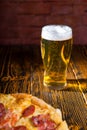 Pizza on wooden table near a glass of beer Royalty Free Stock Photo