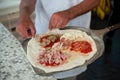 Pizzaiolo puts a four season pizza on the peel, ready to bake. Royalty Free Stock Photo