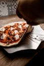 Pizzaiolo's hands making a round pizza on a table in the kitchen of a pizzeria