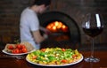 Pizzeria background. Pizza, wine glass, stone stove and chef in italian restaurant.