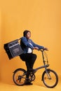 Pizzeria worker carrying food takeaway backpack standing on bike in studio