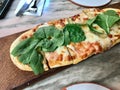 Pizzetta with Rocket Leaves , Arugula or Rucola and Artichoke Slices on Wooden Pizza Board
