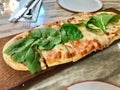 Pizzetta with Rocket Leaves , Arugula or Rucola and Artichoke Slices on Wooden Pizza Board Royalty Free Stock Photo