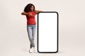 Place For Ad. Positive Black Woman Pointing At Big Blank Smartphone Screen Royalty Free Stock Photo