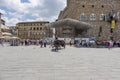 Place called de la Signoria with a typical horse buggy and many tourists strolling on a sunny day, on the right the