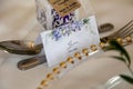 a place card with some flowers on a plate with gold beaded edge