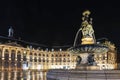 Place de la Bourse at night in Bordeaux, in the foreground, the fountain of the three grace and in the background the buildings of Royalty Free Stock Photo
