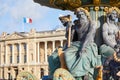 Place de la Concorde fountain statues with golden details and building with french flag in Paris Royalty Free Stock Photo