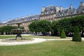 Place des Vosges, ancient buildings and garden in Paris in a sunny day, clear blue sky