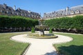 Place des Vosges with fountain in Paris in a sunny morning, clear blue sky Royalty Free Stock Photo