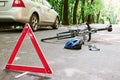 Place of disaster. Bicycle and silver colored car accident on the road at forest at daytime Royalty Free Stock Photo