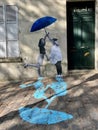 Clever wall art of two women with blue shadows painted on brick plaza, Paris, France