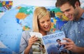 This place has our names written all over it. Shot of a young couple looking at a travel brochure.