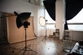 a place for a photo shoot, lighting devices are in a photo studio, a beige otophone is hung up, there is wooden furniture