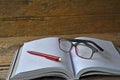 Place red pen and eyeglasses on opened book to stop reading Royalty Free Stock Photo