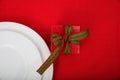 Table setting detail and gift on red tablecloth Royalty Free Stock Photo