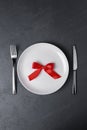 Place setting with high-gloss plate, knife fork. Isolated on black, set table Royalty Free Stock Photo
