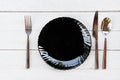 Place setting table food with set of black plate on the table dinner / empty plate spoon fork and knife on wood table , top view Royalty Free Stock Photo
