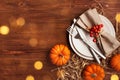 Place setting for Thanksgiving dinner with plate, napkin, cutlery and pumpkins on wooden table top view Royalty Free Stock Photo