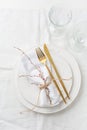 Place setting in white - plates, cutlery in gold, napkin Royalty Free Stock Photo