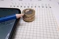 place for text, notebook, graph with pen and euro coins. Close-up of a pen and euro coins on top of a financial graph