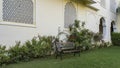 A place to relax in the garden. On the green lawn, against the wall, there is a beautiful bench Royalty Free Stock Photo