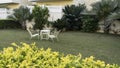 A place to relax in the garden. There are white chairs and a table Royalty Free Stock Photo