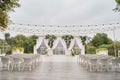 Place for wedding ceremony with wedding arch decorated with palm leaves, orchid flowers and floral peacocks, bulbs garland. Royalty Free Stock Photo
