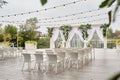 Place for wedding ceremony with wedding arch decorated with palm leaves, orchid flowers and floral peacocks, bulbs garland.