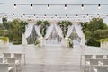 Place for wedding ceremony with wedding arch decorated with palm leaves, orchid flowers and floral peacocks. Royalty Free Stock Photo