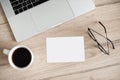 Place of work with laptop, coffee cup, glasses and empty blank paper at office desk, mock up. Copy space. Royalty Free Stock Photo