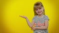 Place for your advertisement logo, little kid child girl showing thumbs up and pointing at left Royalty Free Stock Photo