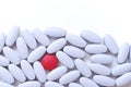 Placebo concept. Single red pill among light blue pills on white background. Royalty Free Stock Photo