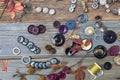 Placer of colorful vintage buttons and dried plants on an wooden surface