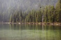 A serene view of String Lake with pine trees lining the water and gorgeous reflections in Grand Teton National Park, Wyoming.