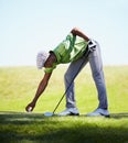 Placing his ball for the final drive. a young african american golfer placing his golf ball on a tee.