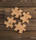 Placing a piece of the puzzle on a textured old wooden table. Royalty Free Stock Photo
