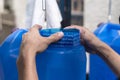 Placing a plastic seal on the lid of a blue 20 liter HPDE water container. A purified water refilling station business Royalty Free Stock Photo