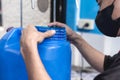 Placing a plastic seal on the lid of a blue 20 liter HPDE water container. A purified water refilling station business Royalty Free Stock Photo