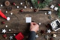 Placing a small blank piece of paper in the center of holiday setting full of christmas ornaments