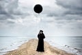 Plague doctor with black balloon in seaside.